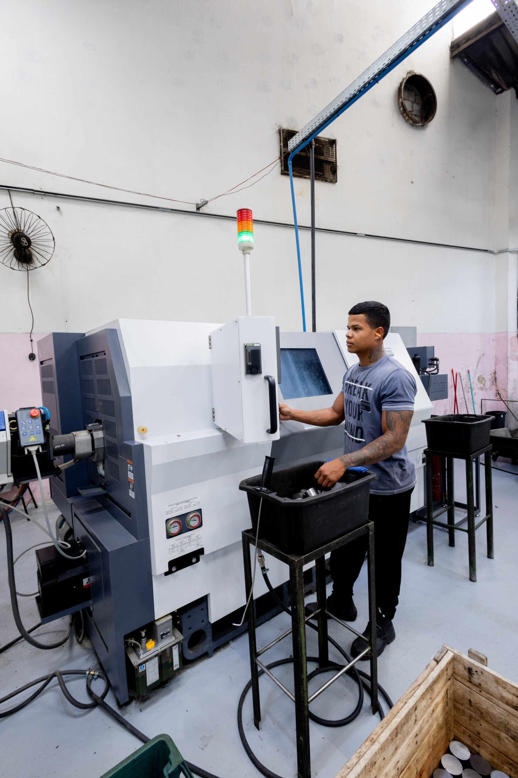 Operador trabalhando em torno automático CNC na fábrica da Mecânica Eloy em São Paulo